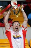 Lamh Dhearg captain Miko Herron lifts teh Intermediate Hurling Championship trophy after his team's battling comeback win over Cloughmills at Casement Park. 