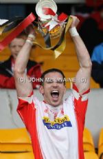 Lamh Dhearg captain Miko Herron lifts teh Intermediate Hurling Championship trophy after his team's battling comeback win over Cloughmills at Casement Park. 