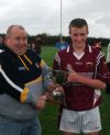 Youth Officer Tony McCollum presents the cup to Stinsons captain James O'Connell