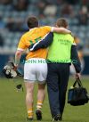 Christopher McGuinness, who had made a promising start to the game, is helped from the field by physio Alastair McKeown after picking up an ankle injury